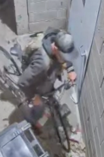 a person on a bike is attempting to break into an apartment building